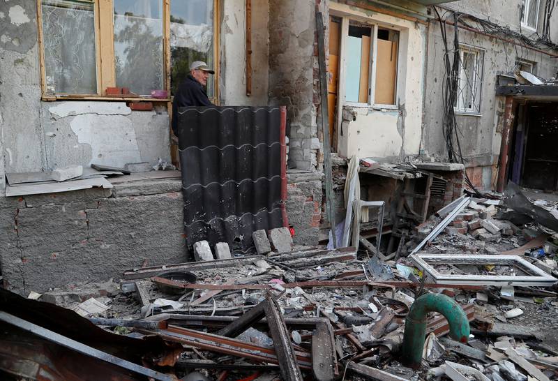 Pensioner Gennady Ivanov, 83, sits outside a residential building heavily damaged by shelling, in Mariupol. Reuters