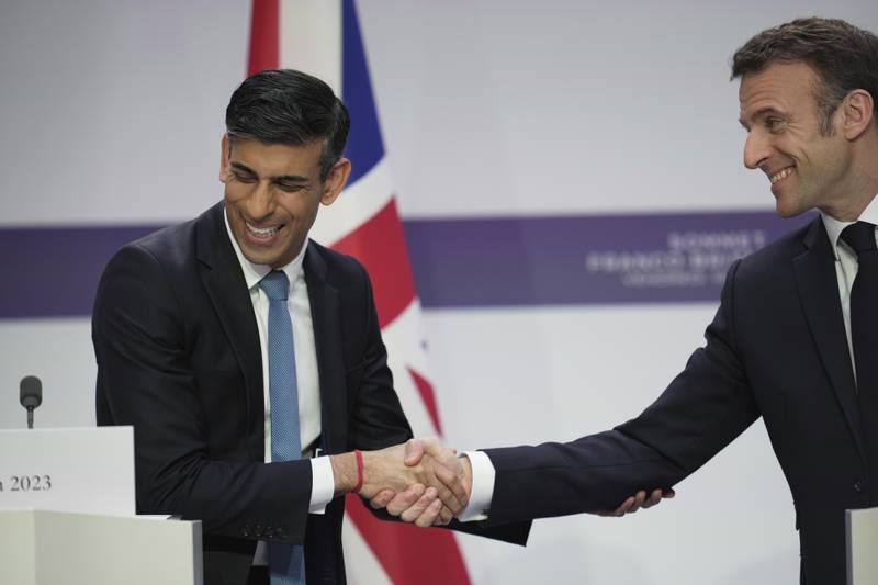 Emmanuel Macron, right, and Rishi Sunak shake hands after signing a deal to stop people crossing the Channel illegally from France to the UK. AP