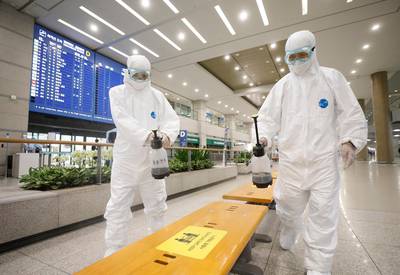 Workers wearing protective gears disinfect chairs as a precaution against the coronavirus at the arrival hall of the Incheon International Airport in Incheon, South Korea. South Korea says 40 more coronavirus patients have died in the past 24 hours, the highest daily fatalities since the pandemic began, as the country is grappling with surging cases in recent weeks. AP Photo