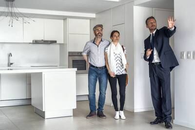 Real estate agent showing kitchen in new house to happy couple
