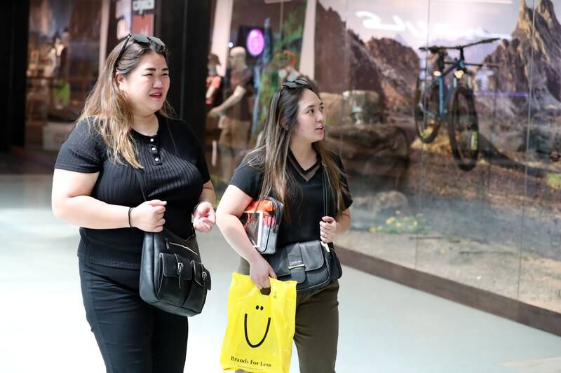 People shop in the Times Square Centre without masks after rules are lifted in malls. Dubai. Chris Whiteoak / The National
