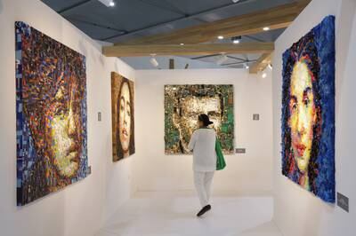 A visitor looks at the 'Zero Point' series of collage portraits by Turkish artist Deniz Sagdic, each of which is made from a particular kind of upcycled waste material. Getty