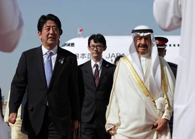 Japanese Prime Minister Shinzo Abe (L) is welcomed by Bahraini Prime Minister Khalifa bin Salman al-Khalifa (R) upon his arrival at the Bahraini airport in Muharraq, on August 24, 2013. AFP PHOTO/POOL/HASAN JAMALI (Photo by HASAN JAMALI / POOL / AFP)