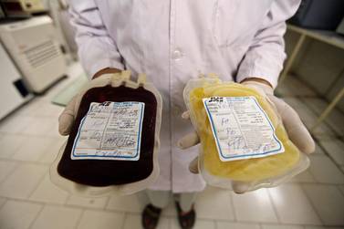 A health worker carries blood bags at a transfusion centre for patients suffering from thalassaemia. Arshad Arbab / EPA