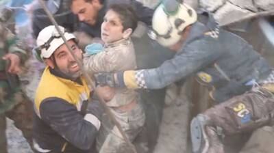 White Helmets volunteers rescue a child trapped beneath the rubble in Jandaris, Syria. Reuters