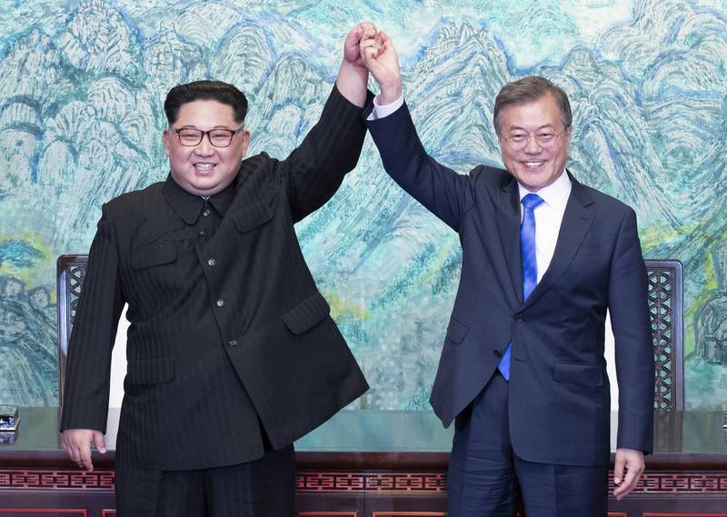 Kim Jong-un and South Korean President Moon Jae-in raise their hands after signing a joint statement in Panmunjom in April 2018. Korea Summit Press Pool / AP