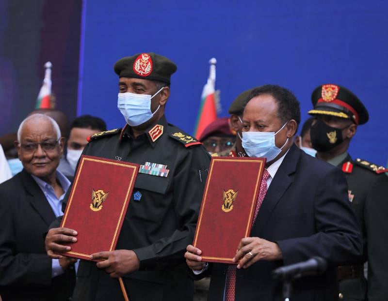 A handout photo made available by the Republican Media Palace shows Sudan's Prime Minister Abdalla Hamdok (Front-R) and Sudan's Top Military Lieutenant General Abdel Fattah Abdelrahman Burhan (Front-2nd R) holding their agreement documents after signing them, in Khartoum, Sudan, 21 November 2021.   Sudanese national television announced on 21 November that Prime Minister Hamadok and  Sudan's Top Military Lieutenant General Burhan signed a political agreement to end the political crisis which started on 25 October.  The agreement reinstates Hamadok as Prime Minister and announces a new transitory period led by military and civilians together.   EPA / REPUBLICAN MEDIA PALACE  /  HANDOUT  HANDOUT EDITORIAL USE ONLY / NO SALES