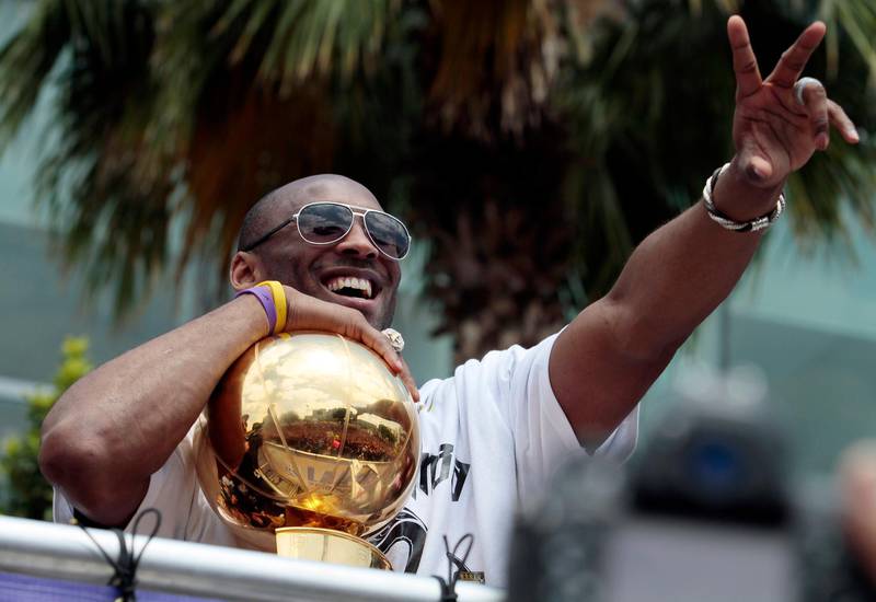 Los Angeles Lakers' Kobe Bryant flashes the victory sign during a parade in downtown Los Angeles. AP Photo/Richard Vogel