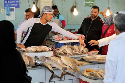 A Saudi fish seller takes a fish at a market on Tarout Island, Saudi Arabia March 9, 2020. Saudi Arabia imposed a temporary lockdown on the Tarout Island following the spread of coronavirus. Reuters
