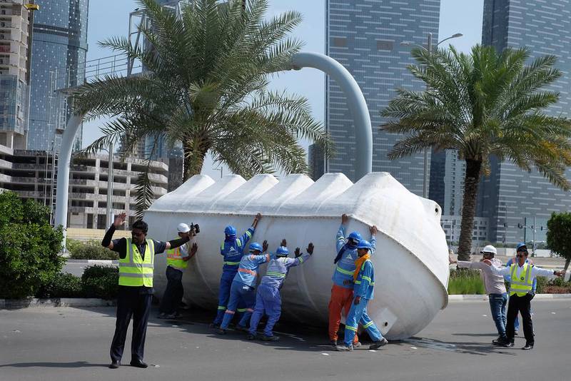Workers attempt to move a large water tank that fell on Reem Island during the Abu Dhabi storm. Delores Johnson / The National