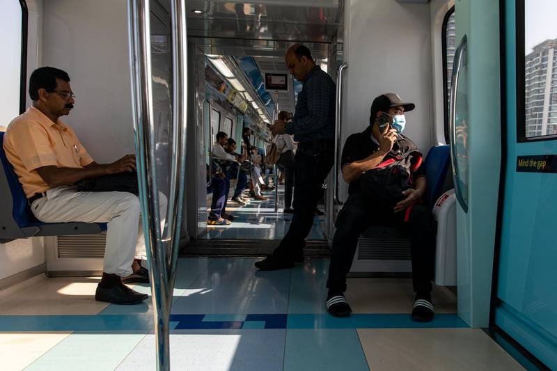 A commuter, wearing a protective face mask, speaks on a mobile phone while riding the metro in Dubai, March 5. Bloomberg