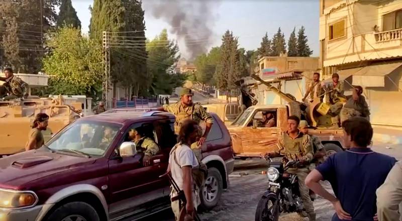 Armed rebel soldiers are seen on the street of Tal Abyad, Syria, in this screen grab taken from video. Reuters