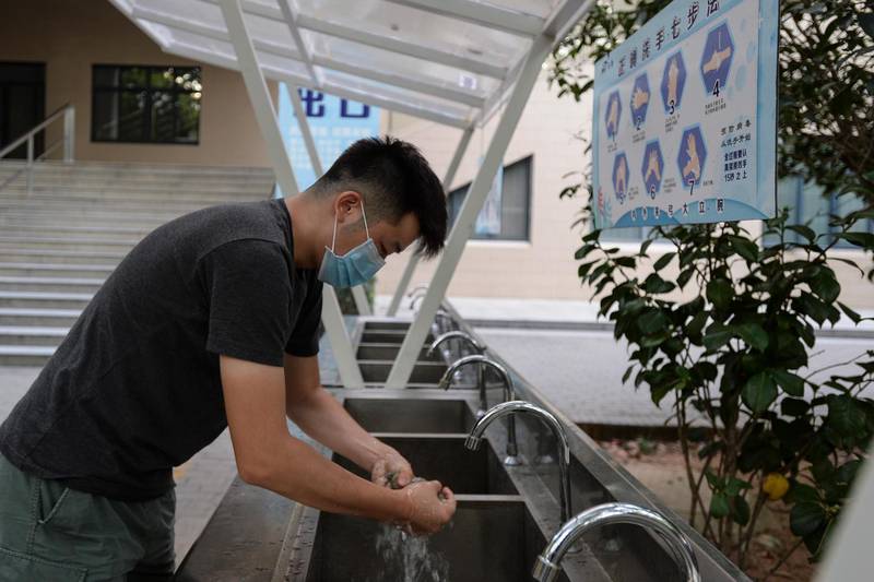 A Huazhong University of Science and Technology student washes his hand on campus in Wuhan, China. EPA
