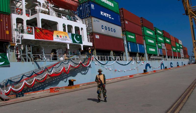 FILE - In this Nov. 13, 2016, file photo, a Pakistan Navy soldier stands guard while a loaded Chinese ship prepares to depart, at Gwadar port, about 700 kilometers (435 miles) west of Karachi. Pakistan. A new study says the massive Chinese infrastructure program called the "Belt and Road Initiative" that Beijing says is aimed at promoting global trade and economic growth is actually intended to expand the country's political influence and military presence. (AP Photo/Muhammad Yousuf, File)