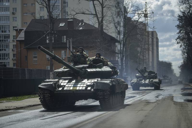 Ukrainian tanks move down a street in Irpin, on the outskirts of Kyiv. AP