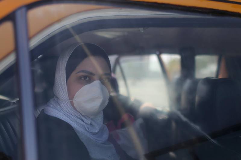 A Palestinian woman wearing a mask looks out of a car upon her return from abroad at Rafah border crossing in the southern Gaza Strip. Reuters