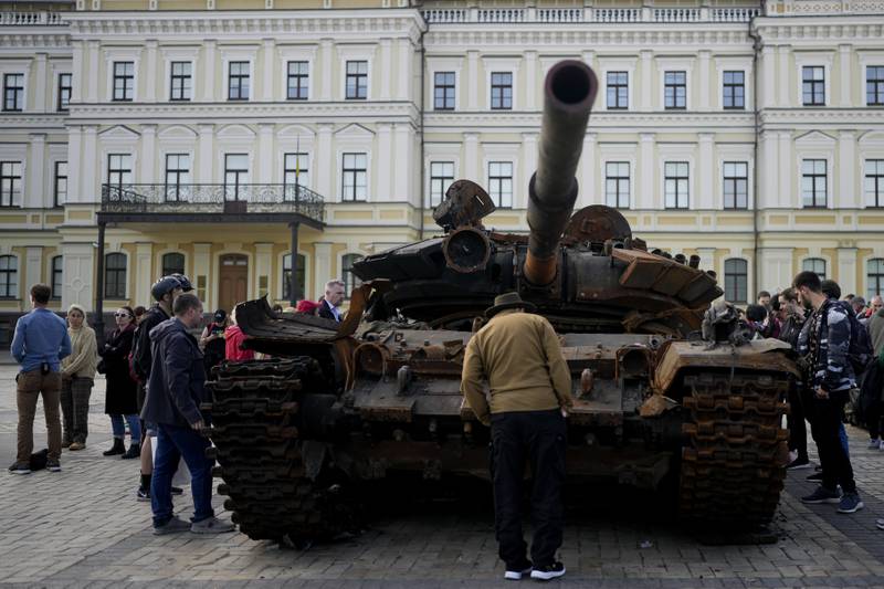 A man looks at a destroyed Russian tank placed as a symbol of war, in central Kyiv. AP