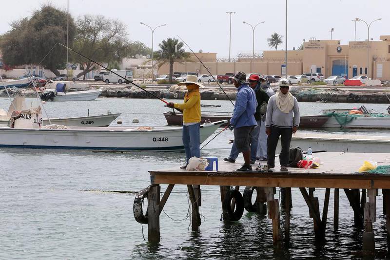 Sharjah resident Eusebio Fernandez, in the yellow shirt, fishes in Umm Al Quwain with friends. Pawan Singh / The National 