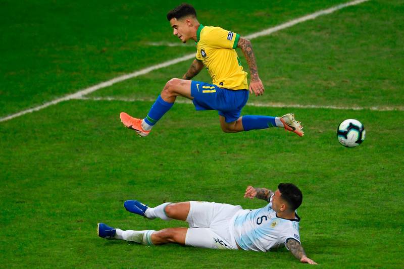 Brazil's Philippe Coutinho jumps over Argentina's Leandro Paredes. AFP