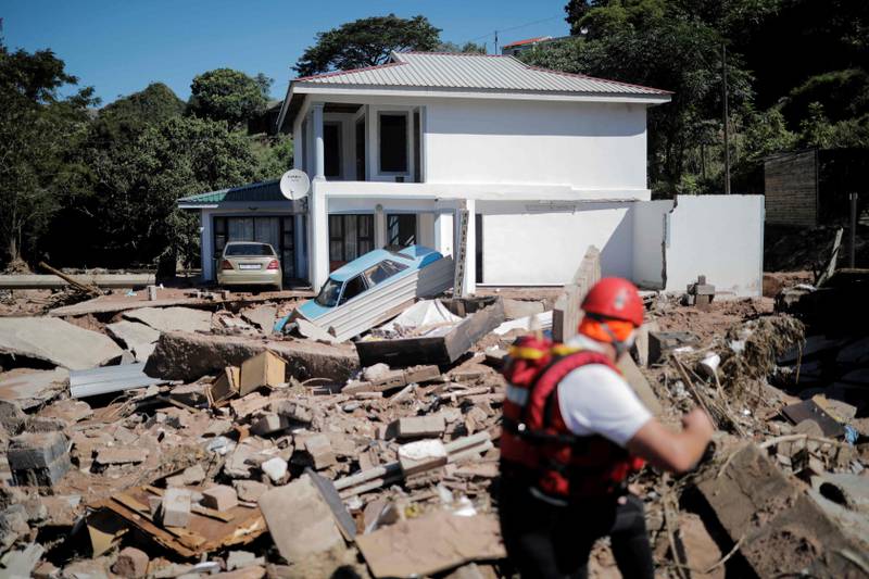 A general view of destroyed structures as a member of the South African Police Service (SAPS) K9 search-and-rescue unit searches for a missing 21-year-old man in KwaNdengezi, west of Durban. AFP