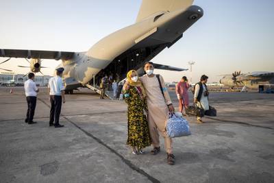 People evacuated from Afghanistan pose in front of a German Bundeswehr airplane after arriving at the airport in Tashkent, Uzbekistan.