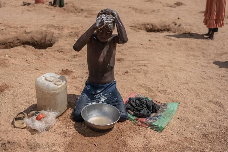 A Sudanese refugee, 9, washes at a waterhole in Metche, Chad, having been displaced by conflict in his homeland. Getty Images