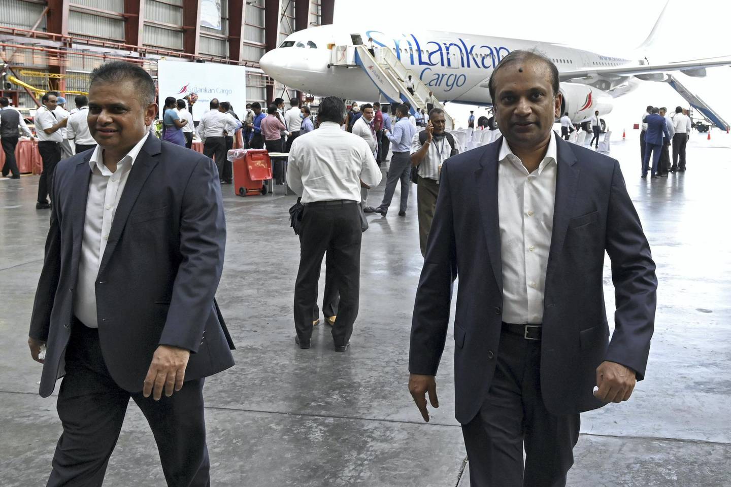 Ashok Pathirage (R) Chairman of Sri Lanka's national carrier Sri Lankan Airlines and its Chief Executive Officer Vipula Gunatilleka walk during the launch ceremony of Airbus A330 passenger aircraft converted as a cargo carrier at Bandaranaike International airport in Katunayaka, near Colombo on June 25, 2020. - The airline said its technical crew carried out the modifications to allow the aircraft  to carry up to 45 tonnes of cargo both in the former passenger deck and the cargo hold at a time when demand for air cargo space has risen while passenger traffic has plummeted due to the coronavirus pandemic. (Photo by ISHARA S. KODIKARA / AFP)
