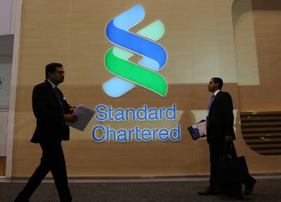 People pass by the logo of Standard Chartered plc at the SIBOS banking and financial conference in Toronto, Ontario, Canada October 19, 2017. Picture taken October 19, 2017. REUTERS/Chris Helgren