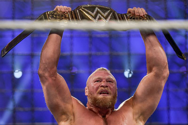 Brock Lesnar holds up the championship belt.