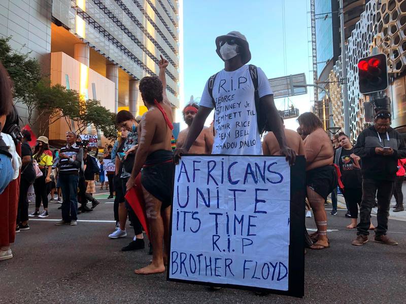 A man holds a placard in solidarity with thousands of people marching during a Black Lives Matter protest in Brisbane.  AP