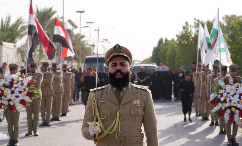 A Peace Brigades member leads a mass funeral in Najaf for Al Sadr supporters killed in the clashes in Baghdad's Green Zone. AFP