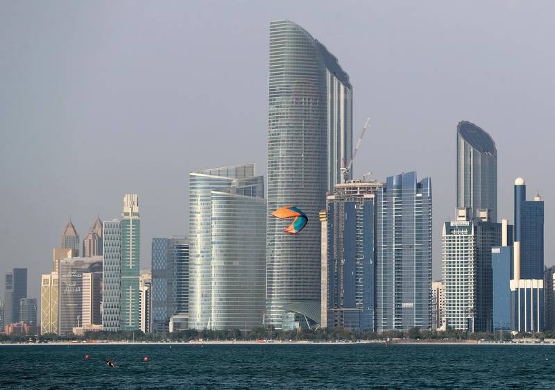 Abu Dhabi, United Arab Emirates - Reporter: N/A: Standalone. A kite surfer performs in the bay in front of the Abu Dhabi skyline at sunset. Monday, April 27th, 2020. Abu Dhabi. Chris Whiteoak / The National
