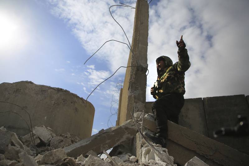 A Kurdish-led Syrian Democratic Forces fighter at a damaged part of the defense wall of Gweiran Prison in Hassakeh. AP