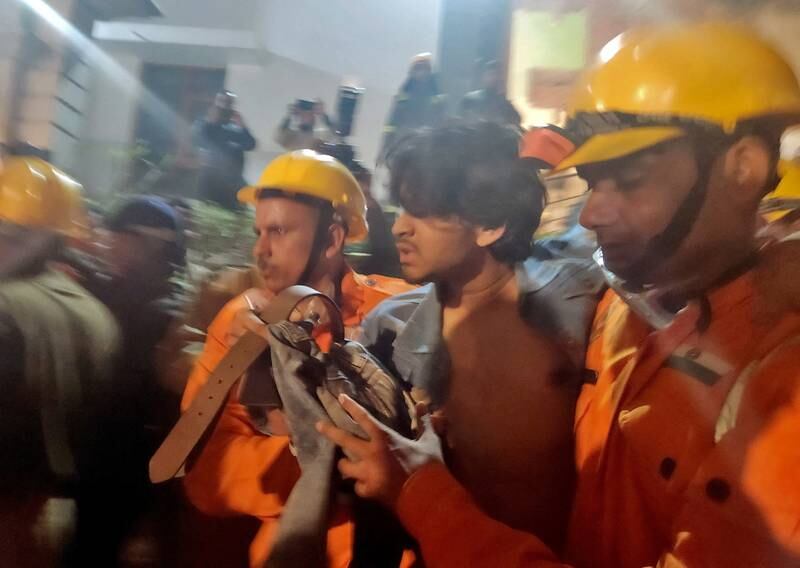 Rescue workers with a man after he was pulled from the debris of the collapsed building. Reuters