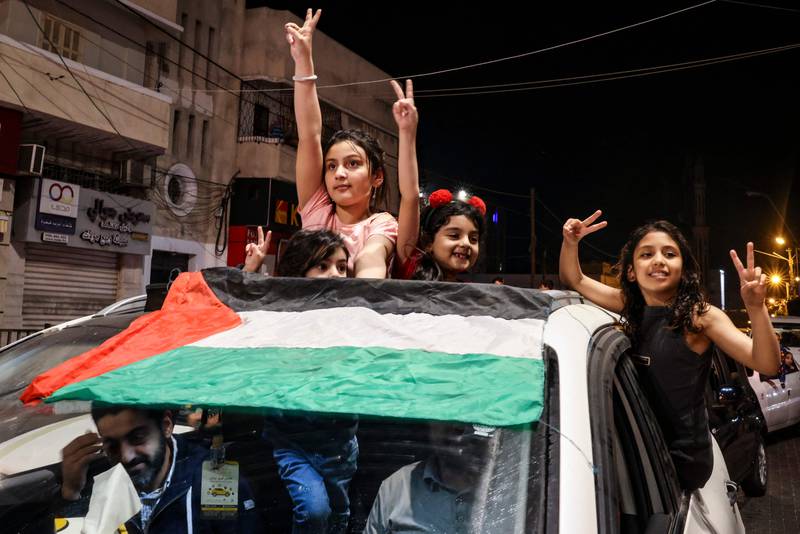 Gaza residents and supporters of the Palestinian Islamic Jihad militant group celebrate on a street in Gaza city, after a ceasefire agreement was reached with Israel on Saturday. All photos: AFP