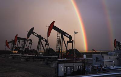 A rainbow appears to come down on pumpjacks drawing out oil and gas from wells near Calgary, Alberta. The Canadian Press