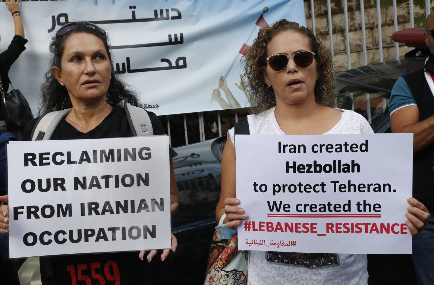 Supporters of Lebanese opposition groups hold placards against Iran and Hezbollah, in Beirut, Lebanon, October  19. AP