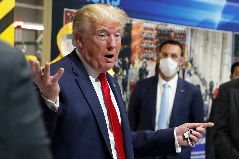 President Donald Trump holds a face mask in his left hand as he speaks during a tour of Ford's Rawsonville Components Plant that has been converted to factory making personal protection and medical equipment. AP