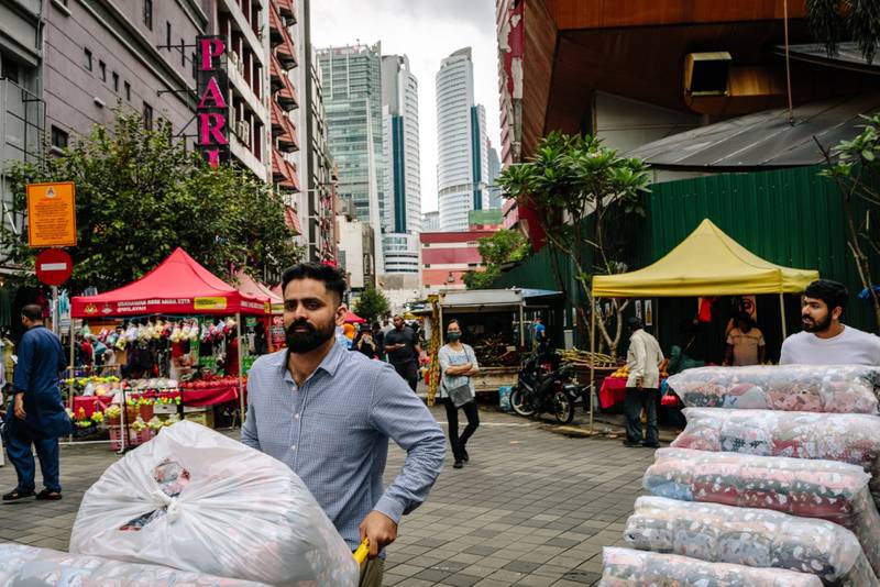 Workers push carts in a shopping area in Kuala Lumpur last week. The Malaysian economy is on recovery mode. Bloomberg
