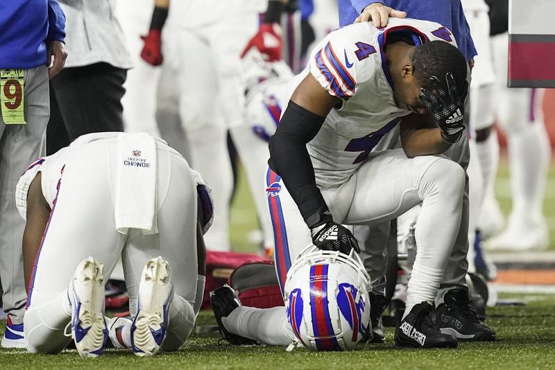 Buffalo Bills players and staff pray for Damar Hamlin during the first half of an NFL football game against the Cincinnati Bengals. AP