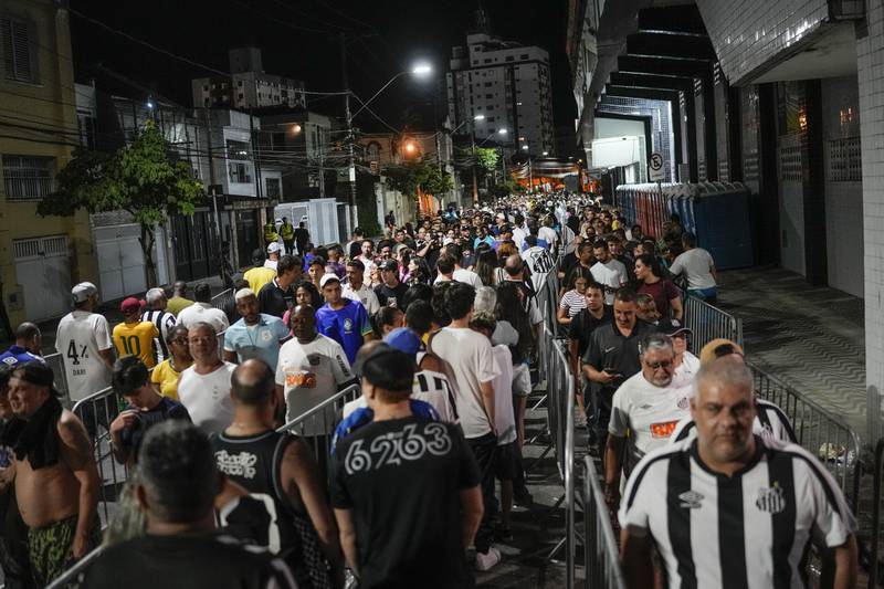 Fans line up to attend the funeral ceremony of Pele in Santos. AP
