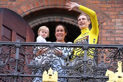 Danish rider Jonas Vingegaard with his wife Trine Maria Hansen and their daughter Frida on the balcony of the City Hall in central Copenhagen. EPA