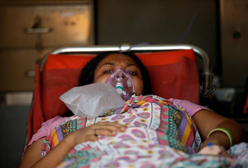 A patient wears an oxygen mask as she lies inside an ambulance waiting in a queue to enter a Covid-19 hospital in Ahmedabad, India. Reuters