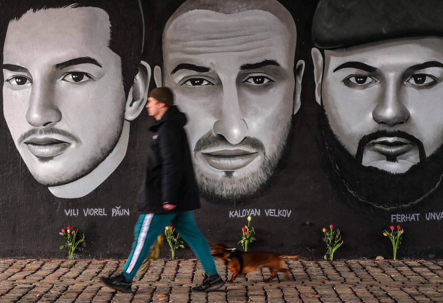 A man passes in front of a mural with portraits of victims of the 2020 Hanau shootings under a bridge in Frankfurt am Main, western Germany, on February 18, 2021, one day before commemorations to honour the victims.   The Hanau shootings occurred on February 19, 2020, when a gunman later identified as Tobias R. killed nine people by opening fire in two bars in the German city of Hanau near Frankfurt/Main. The 43-year-old man was later found dead alongside the corpse of his mother in his home, leaving behind a 24-page xenophobic "manifesto". 
 - RESTRICTED TO EDITORIAL USE - MANDATORY MENTION OF THE ARTIST UPON PUBLICATION - TO ILLUSTRATE THE EVENT AS SPECIFIED IN THE CAPTION
 / AFP / Armando BABANI / RESTRICTED TO EDITORIAL USE - MANDATORY MENTION OF THE ARTIST UPON PUBLICATION - TO ILLUSTRATE THE EVENT AS SPECIFIED IN THE CAPTION
