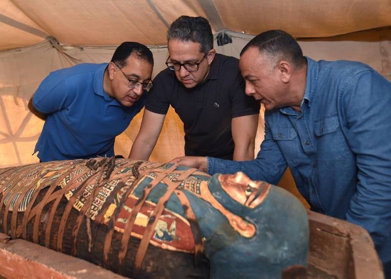 Egyptian Prime Minister Mostafa Madbouly, left, Egyptian Minister of Antiquities Khaled El Enany, centre, and secretary-general of the Supreme Council of Antiquities, Mostafa Waziri ,look at one of the coffins. EPA