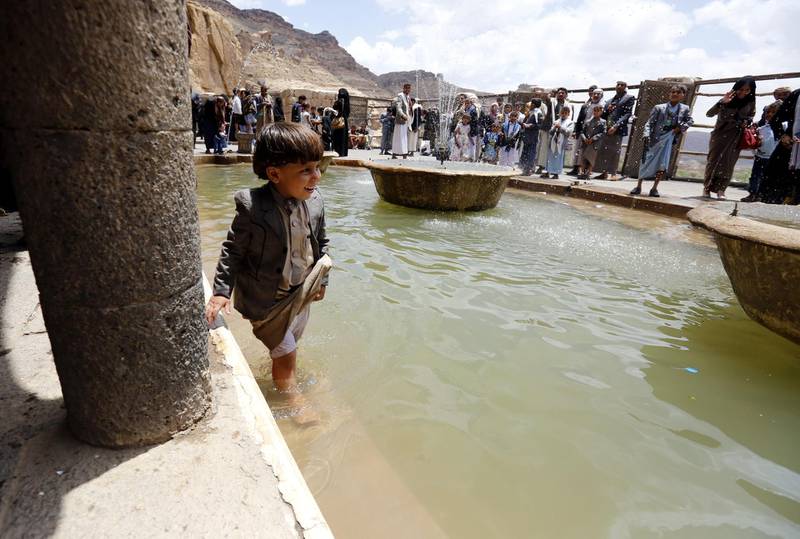 A Yemeni child cools off in a fountain at a historical site on the outskirts of Sanaa, Yemen, during Eid al-Fitr.  EPA
