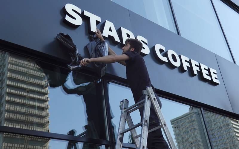 A worker unveils the name of the Stars Coffee chain, which is opening in former Starbucks coffee shops in Russia, at a store on Novy Arbat street, in Moscow, Russia.   EPA