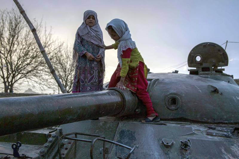 In Kandahar, where playgrounds are largely unavailable, children play on an old Soviet tank. Conflict is all-present in the southern province and eighteen years of American invasion haven't defeated the Taliban. Photo by Stefanie Glinski
