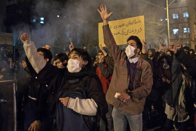 Iranians chant slogans and hold a placard reading in Farsi "Your mistake was unintentional, your lie was intentional" during a demonstration outside Tehran's Amir Kabir University. AFP