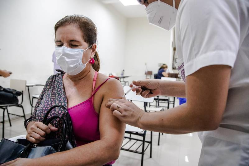 A healthcare worker administers a dose of the AstraZeneca Plc Covid-19 vaccine, provided through the Covax initiative, at the San Pablo Hospital in Asuncion, Paraguay, on Friday, March 26, 2021. Taiwan donated helicopters and Covid-19 drugs to its one remaining South American ally this week amid reports that China is pressuring Paraguay to break with Taipei in exchange for vaccines. Photographer: Maria Magdalena Arrellaga/Bloomberg